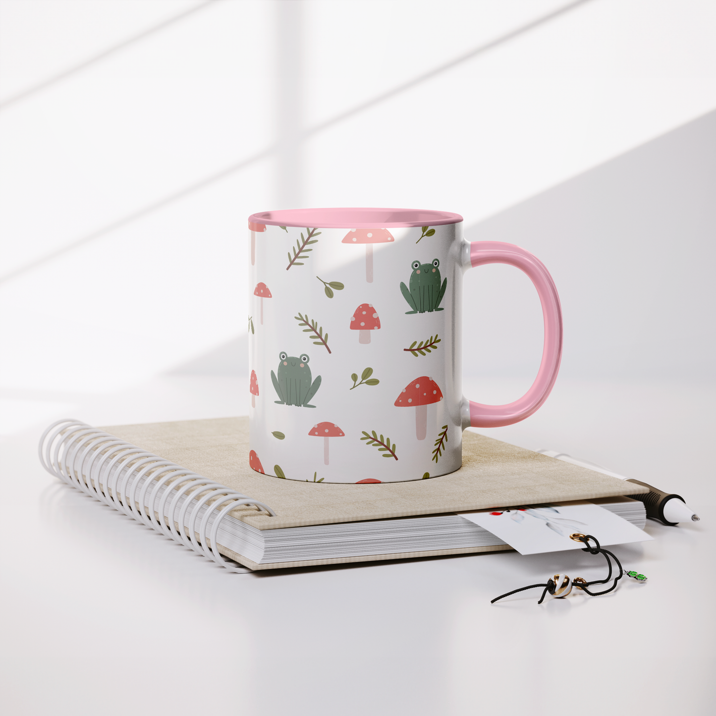 11oz_mug_Mushrooms_and_Frogs_Fairecom_Lifestyle_Notebook_Mockup.png