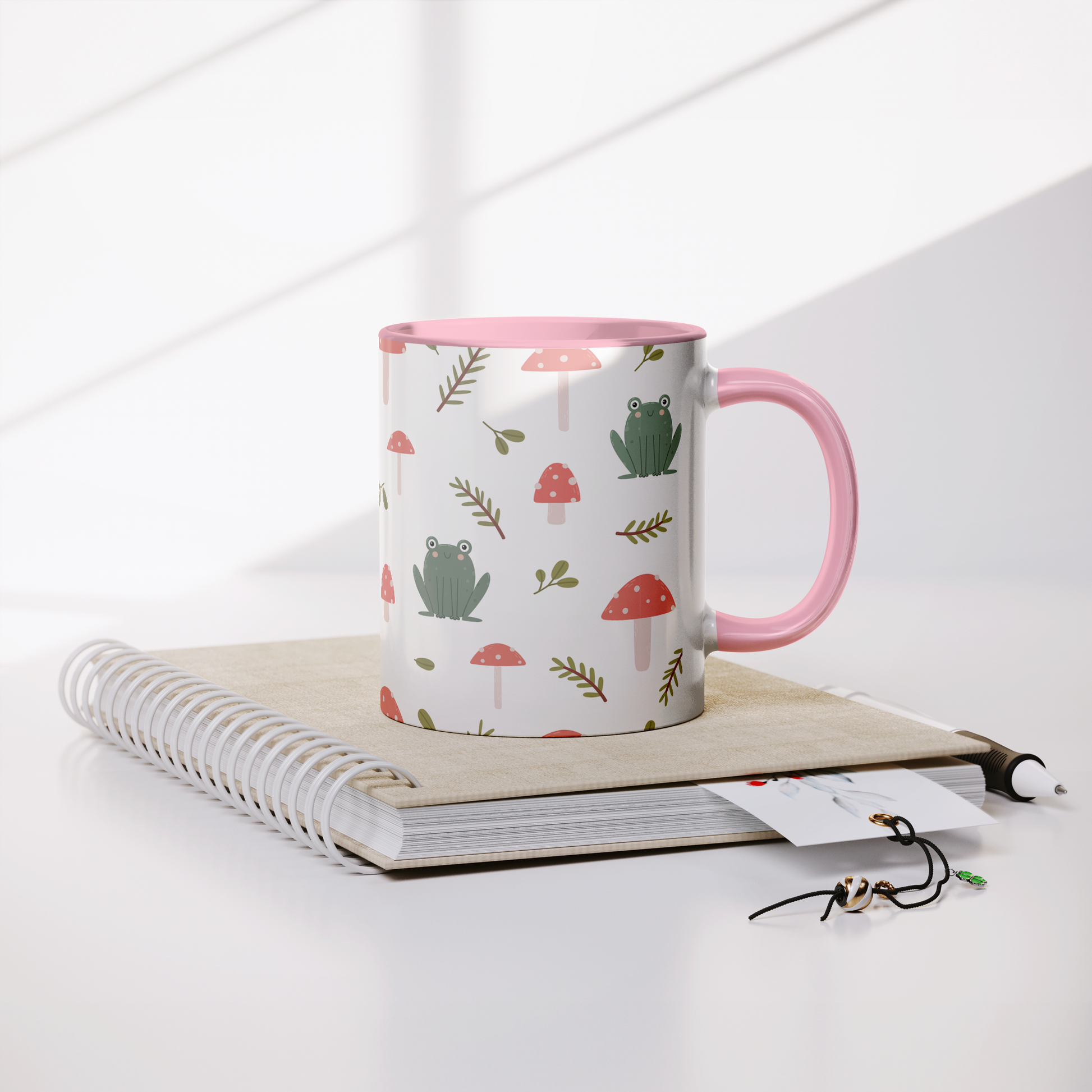 11oz_mug_Mushrooms_and_Frogs_Fairecom_Lifestyle_Notebook_Mockup.png